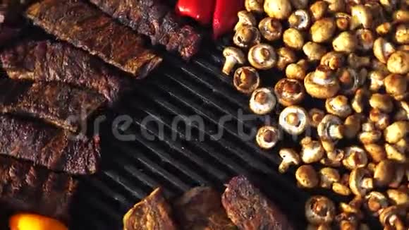 用t骨牛排和蘑菇在烤肉上搭配美味的烤肉和蔬菜大型烤架野战厨房f视频的预览图