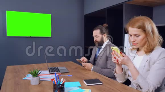 两个办公室工作人员在电视上用绿色屏幕分散他们的注意力视频的预览图