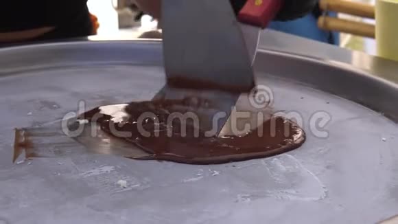 在冷冻锅上做炒冰淇淋卷的过程加卷冰淇淋牛奶手工甜点巧克力特写视频的预览图