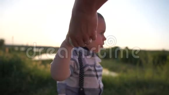 母亲用餐巾纸缓慢地孩子的手擦在草地上视频的预览图