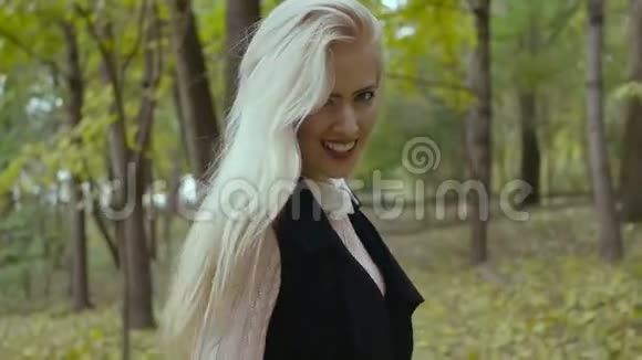 美丽迷人的年轻女孩走在秋天公园调情摆姿势为相机微笑视频的预览图