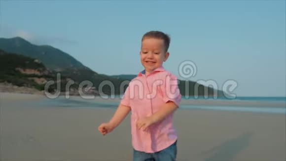 快乐的孩子沿着海滩跑孩子们脚在潮湿的沙滩上漫步在热带海滩上的剪影视频的预览图