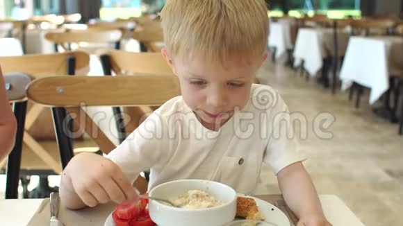 心烦意乱的小男孩在餐厅吃燕麦片他不想吃视频的预览图