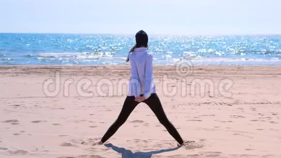 女人做三角瑜伽姿势沙滩运动锻炼适合后景视频的预览图