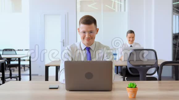 肖像商人使用笔记本电脑显示工作场所的标志OK视频的预览图