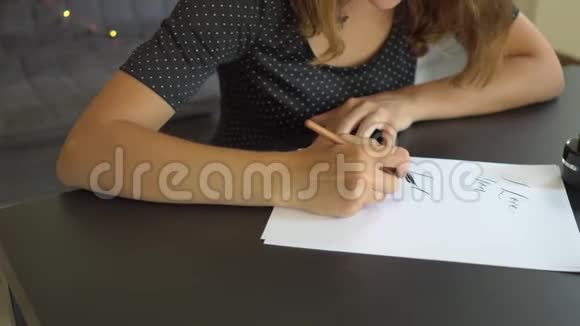 一位年轻女子用刻字技巧在纸上书写书法的特写镜头她说我爱你视频的预览图