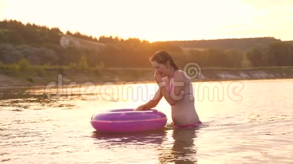 穿着泳衣的美丽而快乐的女孩潜入水中的充气圈笑了起来暑假视频的预览图
