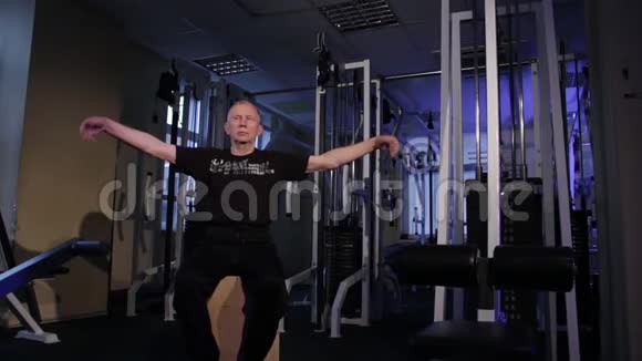一个同龄的人在健身房为手腕做关节体操手腕旋转复制空间视频的预览图