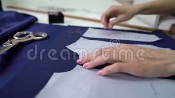 裁缝手把纸样钉在织物上视频的预览图