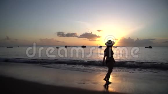女子在沙滩日落漫步慢动作视频4K视频的预览图