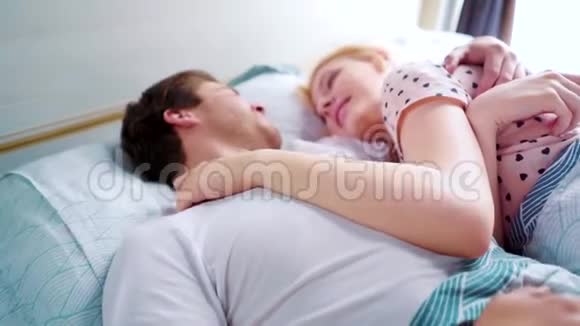 夜里躺在床上的男女青年早晨彼此微笑视频的预览图