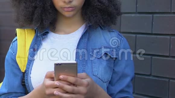 扰乱双种族少女在手机上阅读嘲弄信息网络欺凌视频的预览图