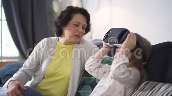 像她的小孙女一样看着她玩的高级女人使用了新的未来技术视频的预览图