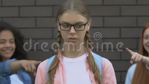 卑鄙的青少年用手指指着戴眼镜的女孩残忍和憎恨同龄人视频的预览图