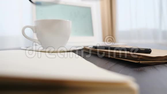 商业概念快关门眼镜放在记事本上白色笔记本和一杯咖啡背景眼镜钢笔视频的预览图