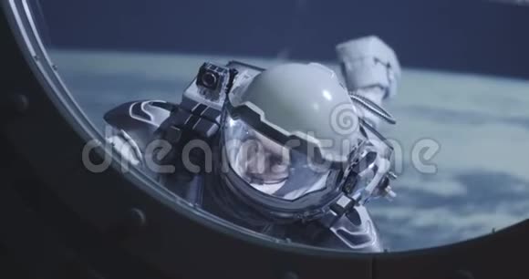 太空人漂浮在太空船的窗户上视频的预览图