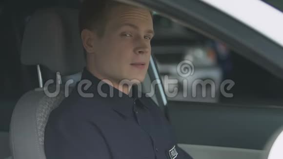 盯着坐在巡逻车驾驶座上的窗户的警察视频的预览图