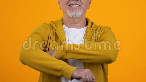 笑容成熟的男人穿着休闲装双臂叠在橙色背景上健康视频的预览图