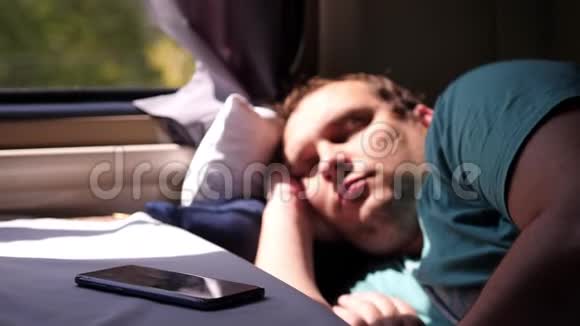 火车上的人睡在电话旁边火车上的人累了坐火车长途旅行视频的预览图