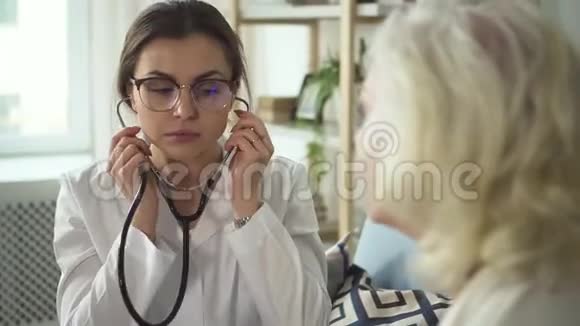 使用听诊器的医生在她家拜访高级妇女视频的预览图