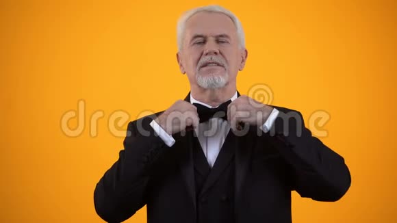穿西装调整领结和发型风格和时尚的英俊老年男性视频的预览图