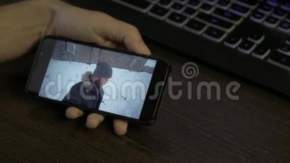 一个长胡子的生活方式男人在冬天的一天和他的朋友在外面拿着智能手机在线视频聊天视频的预览图