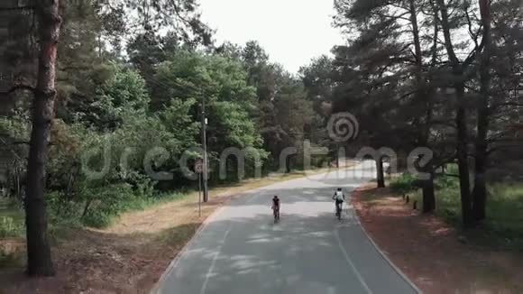穿着粉红色衣服和黑色头盔的女可爱自行车运动员在公园里骑自行车作为她训练常规的一部分骑单车视频的预览图