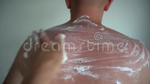 用双酚油涂抹在晒黑的男性皮肤上视频的预览图