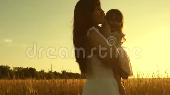 妈妈和女儿在日落时正在一片小麦成熟的田野里闲逛快乐的母亲一个小孩充满了视频的预览图