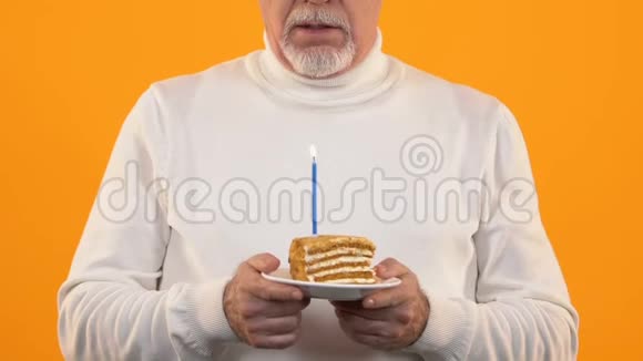 悲伤的退休男子吹着蛋糕蜡烛生日时感到孤独失望视频的预览图