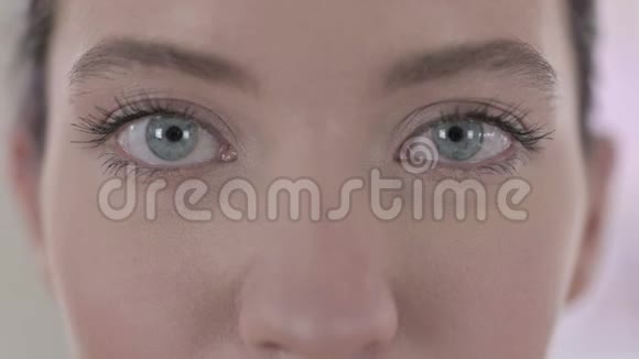 年轻白女眨眼的迷人蓝眼睛肖像视频的预览图