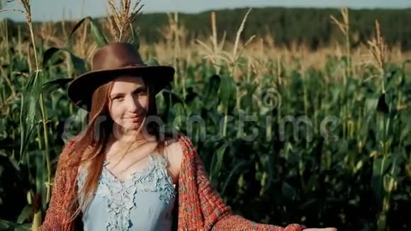帽子里的年轻农民女孩的肖像在有机农场用手展示了她的玉米田微笑着看着女孩视频的预览图