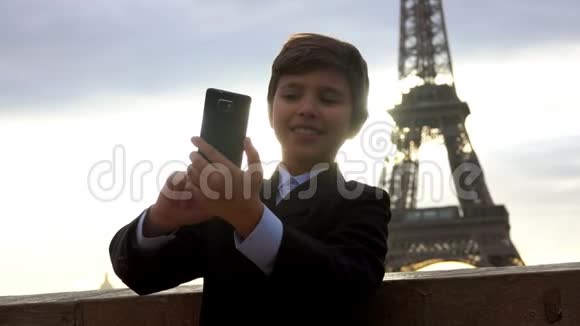 男孩在埃菲尔铁塔的背景下自拍视频的预览图