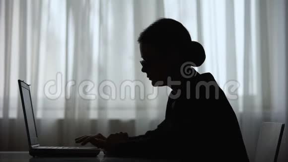 女性在笔记本电脑上的智能手机上阅读信息的影子自由职业者视频的预览图
