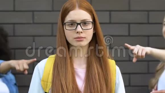 十几岁的孩子戴着眼镜指着红头发的女孩嘲笑书呆子视频的预览图