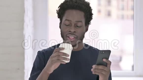 非裔美国年轻人喝咖啡和使用智能手机的肖像视频的预览图
