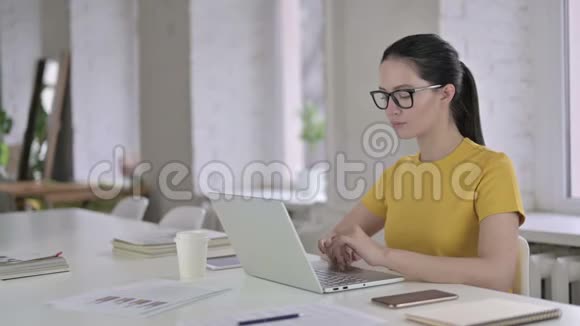 现代办公室颈部疼痛的年轻女设计师视频的预览图