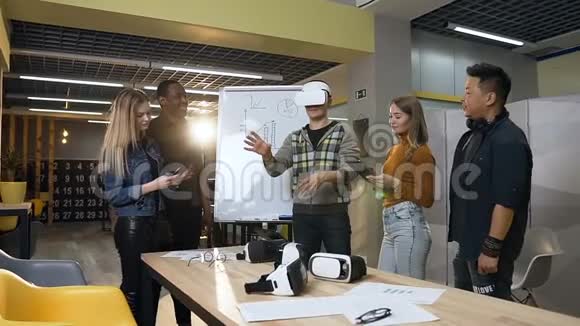 白种人专注于虚拟现实眼镜玩游戏时玩得很开心而他的牛仔则在平板电脑上工作视频的预览图