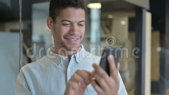 现代办公中使用智能手机的英俊非洲男子视频的预览图