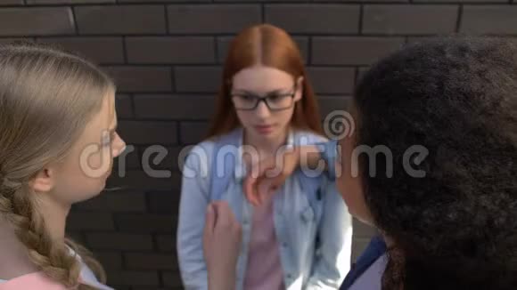 欺负女孩的女孩从不安全的女学生手中拿走眼镜嘲笑书呆子视频的预览图