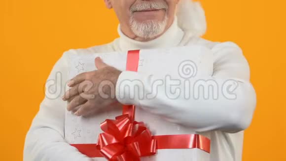 喜气洋洋的灰胡子男拿着红丝带礼盒送上幸福视频的预览图