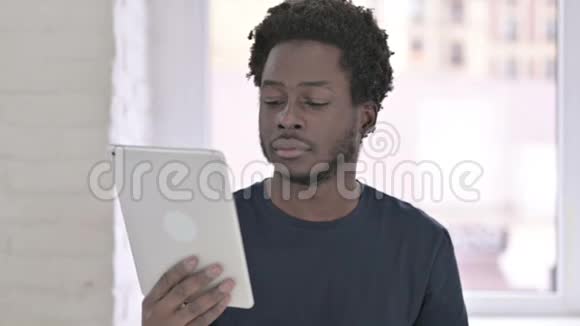 在办公室使用平板电脑的雄心勃勃的非裔美国年轻人的肖像视频的预览图