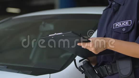 女停车管理员在罚单上签字并将其贴在汽车挡风玻璃上视频的预览图