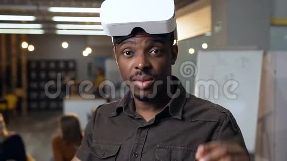 在办公室工作时戴着虚拟现实虚拟现实眼镜的非洲商人视频的预览图