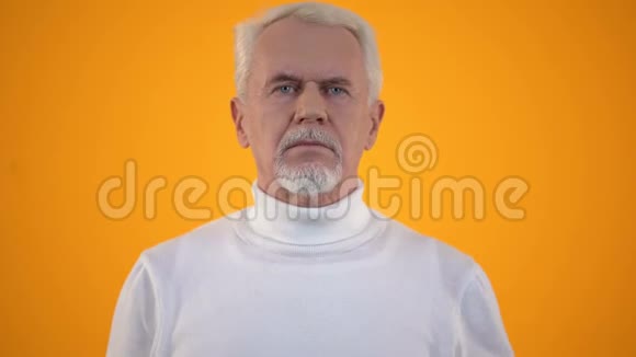 男性退休老人梳着灰白的头发目不转睛地看着毛刷毛发视频的预览图