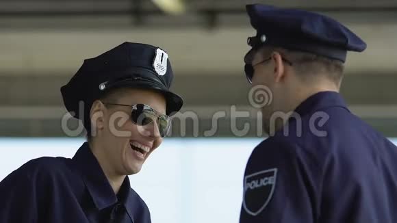 男女警察搭档大笑在城市巡逻时休息休息视频的预览图