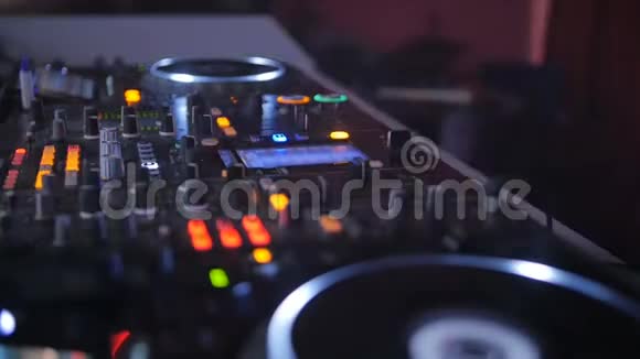 一个DJ在控制台后面在舞台上混合轨道在大气舞蹈派对闪光灯和闪光灯视频的预览图