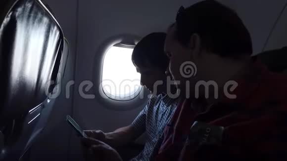 两个人在飞机上看手机视频的预览图