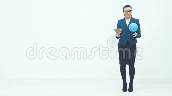 一个聪明的商业女人站在白色的背景上持有一大笔钱和一个地球仪对自己充满信心视频的预览图