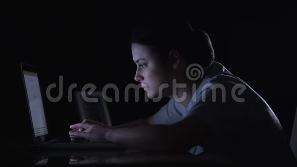 女士在黑暗的房间里用笔记本电脑打字看着照片微笑着思念的女儿视频的预览图